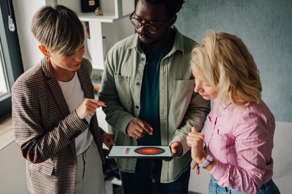 Marketing team analyzing charts on digital tablet in office meeting