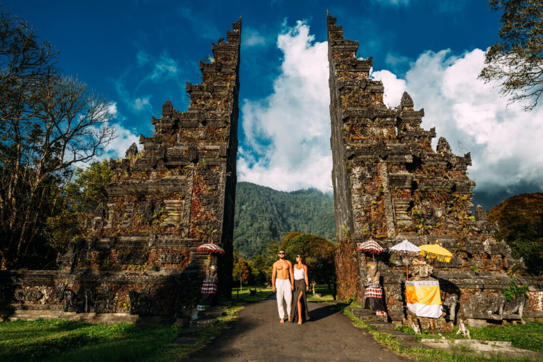 Beautiful couple at the Bali temple. Man and woman traveling in Indonesia. Couple at the Bali gate