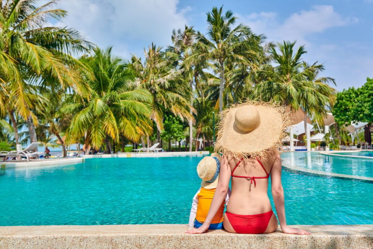 Toddler boy in resort swimming pool with mother
