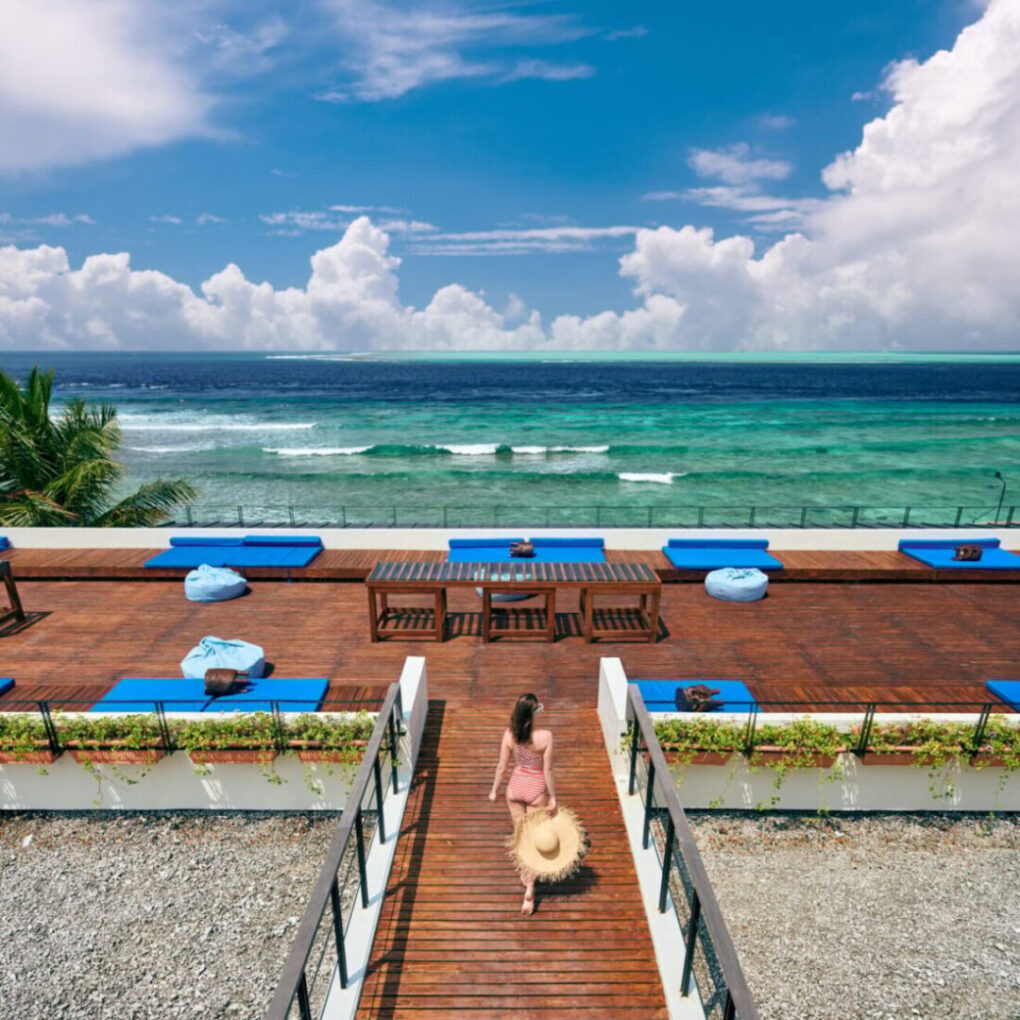 Woman in striped swimsuit on beach patio