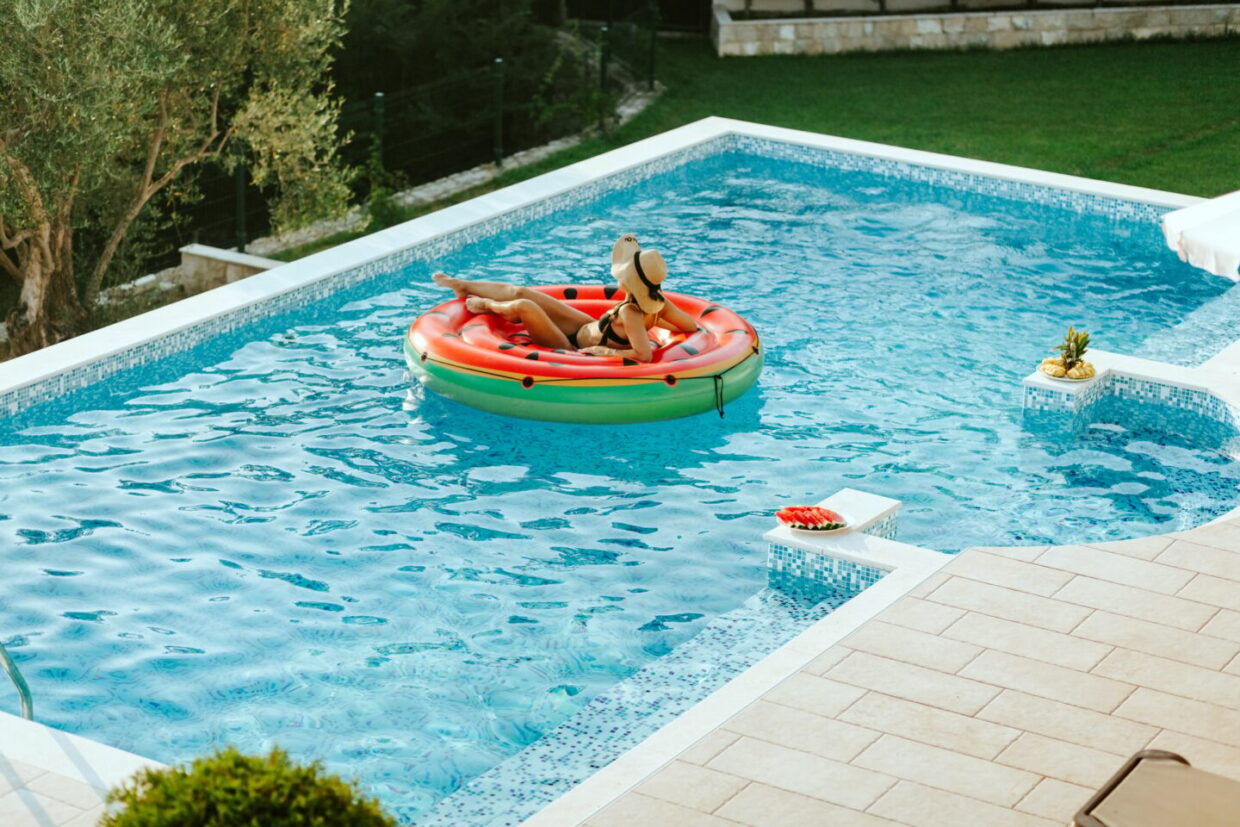 woman relax in swimming pool on inflatable pool toy at summer day