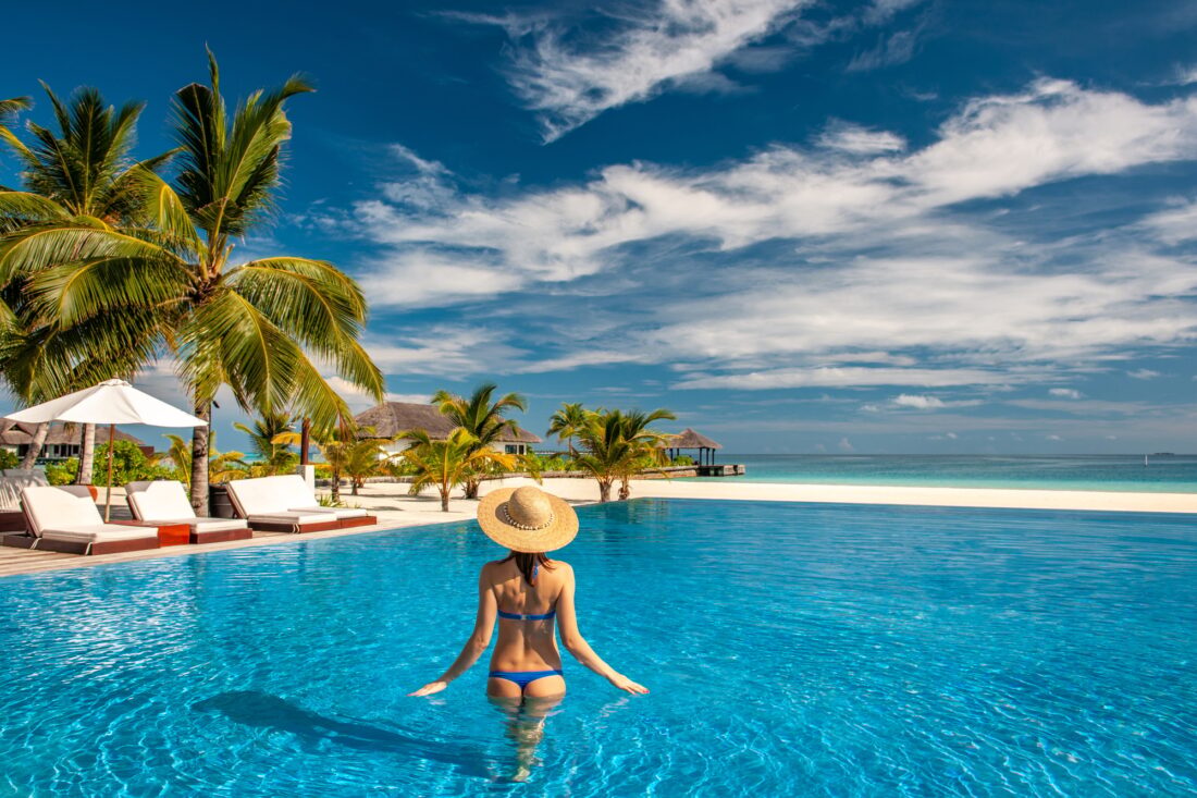Woman with hat at beach pool in Maldives