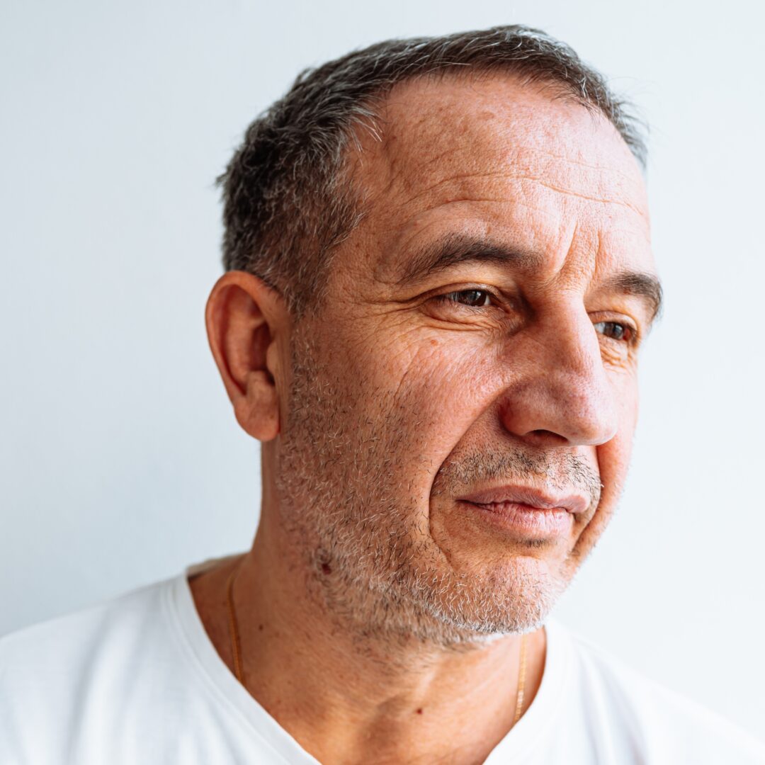 Portrait of middle-aged man with brown eyes, gray hair, mimic wrinkles on face