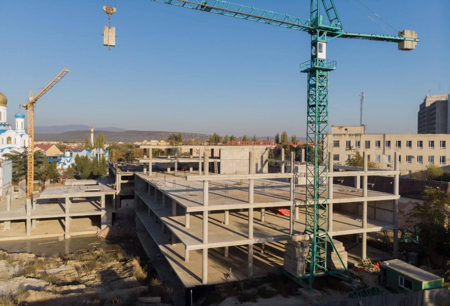 Crane and building construction site against blue sky and building houses