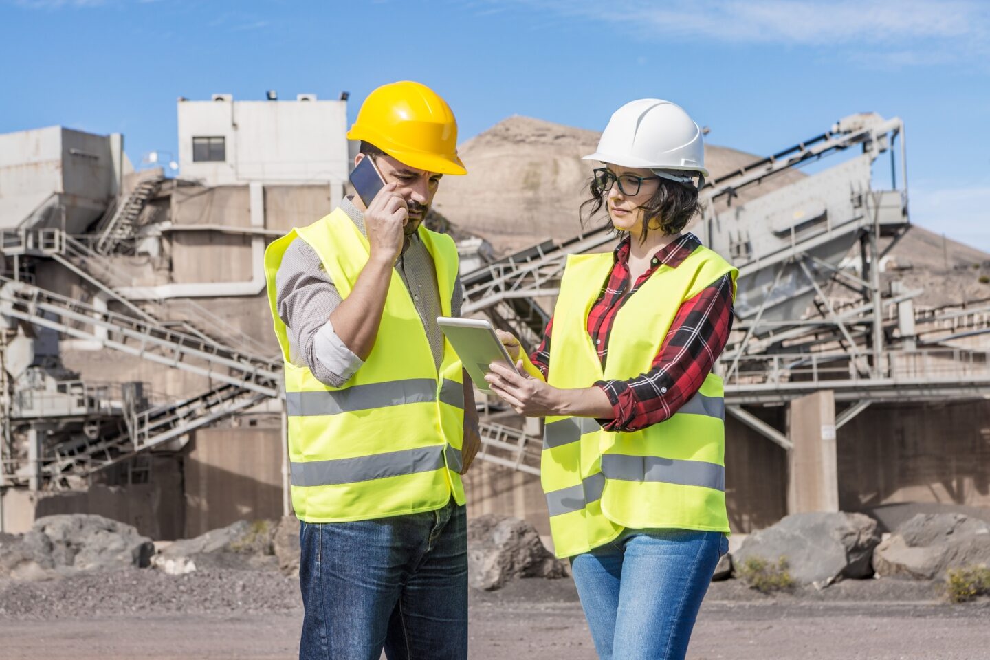Engineers with modern gadgets working on construction site